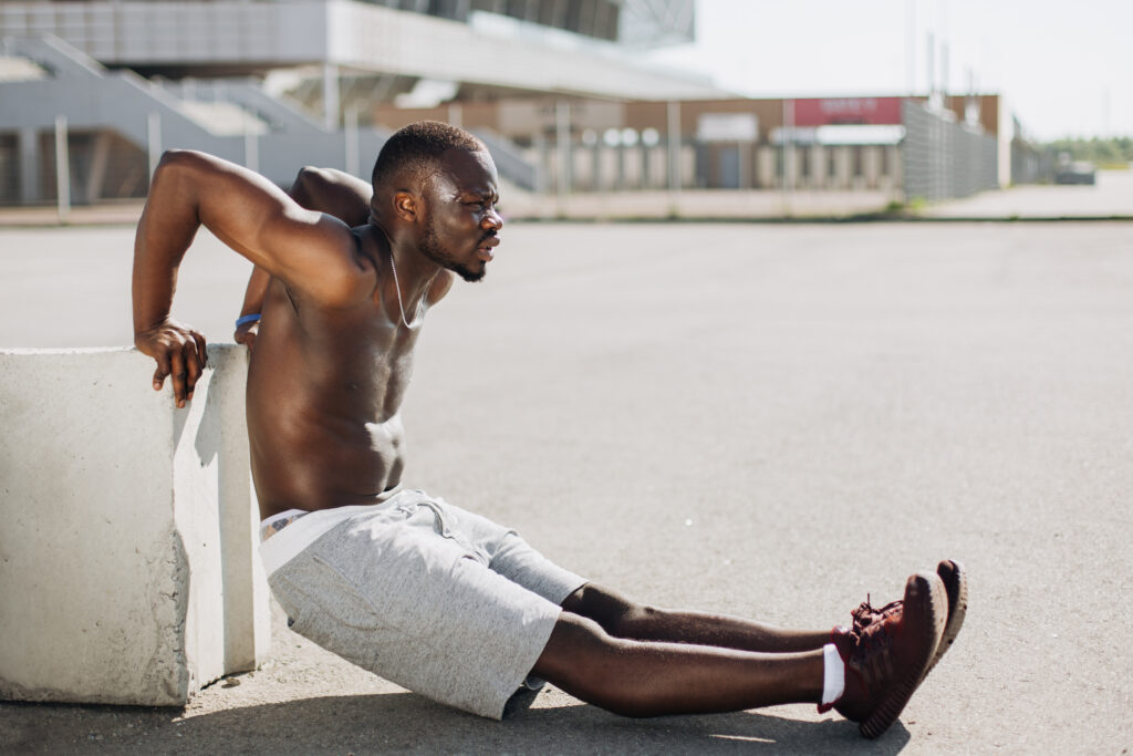 African American man does pus-ups on the street during his morning work-out